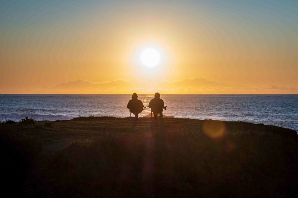 Couple Sitting on beach enjoying sunset