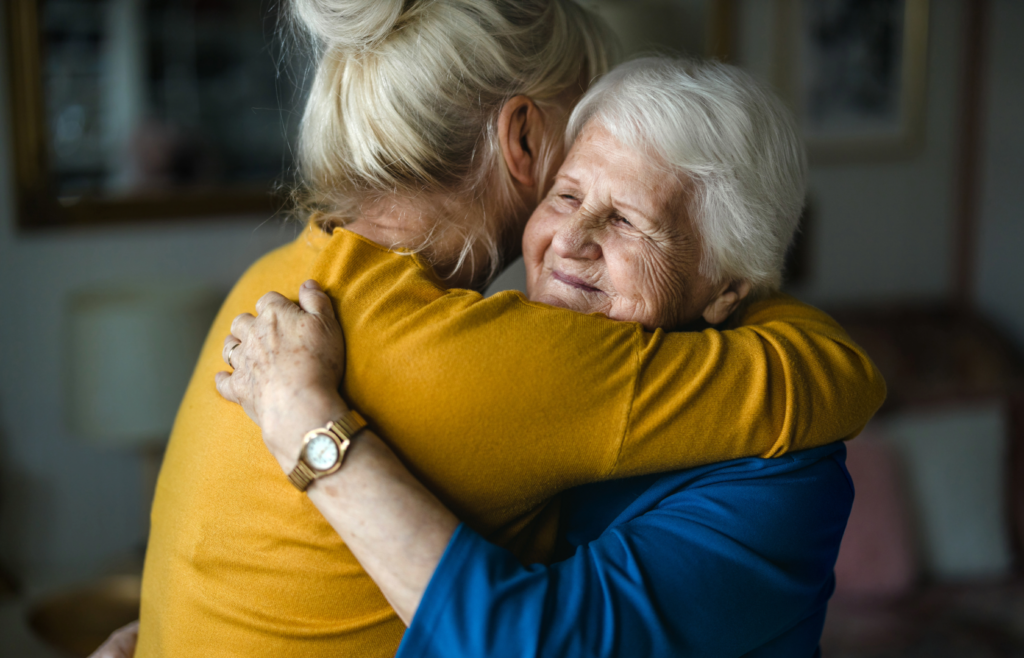 Woman hugging elderly woman