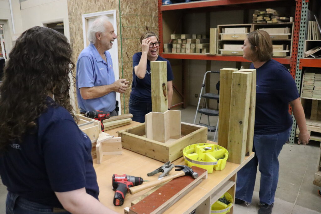 Intandem Credit Union team members sharing a lighthearted moment with a Home Repair Services volunteer during a community involvement project.