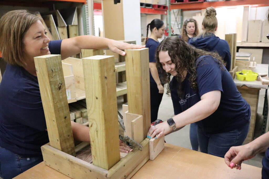 Intandem Credit Union employees building logoed tables for Home Repair Services